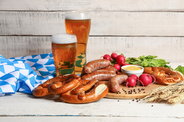 Glasses of cold beer and plate with different snacks on light wooden background. Oktoberfest...
