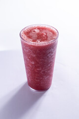 Suco de melancia em um copo de vidro com fundo branco