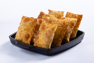 Porcão de pastéis em uma cumbuca preta, em um fundo branco