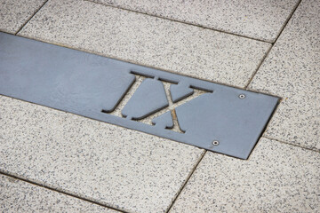 Roman numerical number nine made of stone tiles on street