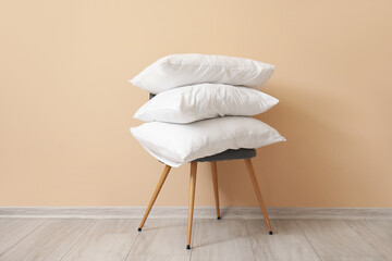 White pillows on chair near beige wall