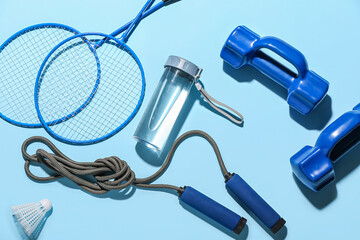 Composition with sports equipment and bottle of water on color background