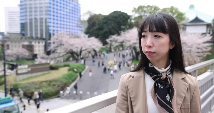 A portrait of Japanese woman behind cherry blossom in Tokyo copyspace