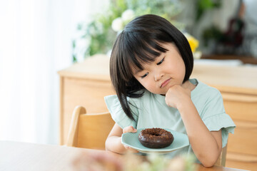 チョコレートドーナツを食べる子供