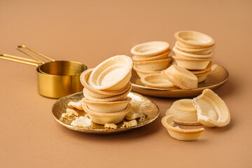 Plates with homemade tartlets on brown background