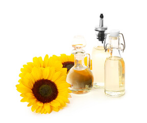 Bottles and decanter with sunflower oil on white background