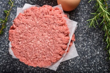 Art of Preparation: Close-Up of Raw Hamburger Patty on a Wooden Board, Ready to be Seasoned, Showcasing the Essence of Culinary Craftsmanship in 4K Resolution