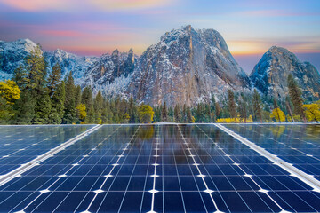 Solar panels with mountain landscape at sunset. Green energy concept.