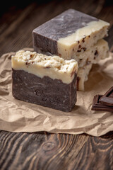 Pieces of natural handmade chocolate soap on a kraft paper wrapper on a wooden table