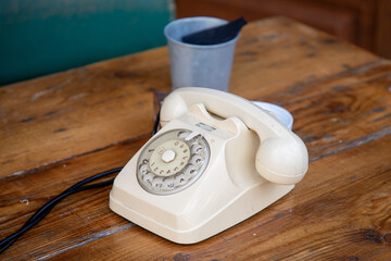 Old dial phone beige retro ancient style Telephone on wooden table