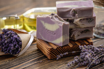 Pieces of traditional French soap on a wooden soap dish and a bouquet of lavender. Natural handmade...