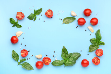Frame made of fresh basil, cherry tomatoes and peppercorn on blue background