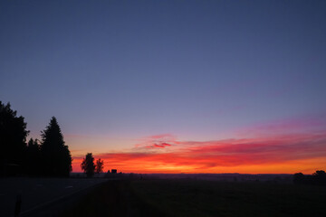 Naklejka na ściany i meble Radiant Dawn: Majestic Colorful Sunrise Painting the Summer Fields in Northern Europe
