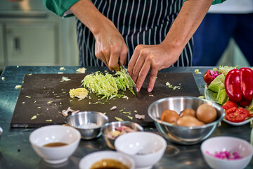 Chef assistant cutting fresh savoy cabbage in the kitchen for make a food