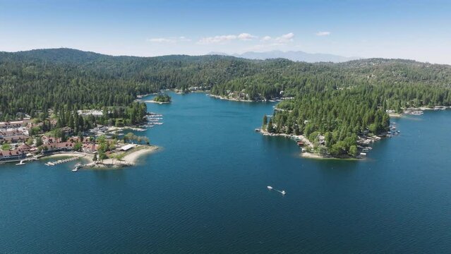 Drone shot of picturesque Lake Arrowhead in the San Bernardino Mountains, Los Angeles, California, USA. Overhead view of private villas located on lake shore surrounded green mountains, 4k footage