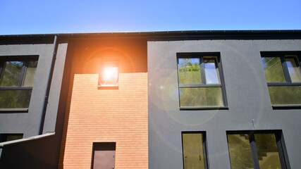 New single family houses in a new development area. Residential homes with modern facade. Terraced family homes in newly developed housing estate. The real estate market in the suburbs.