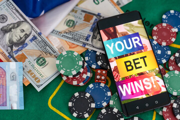 Ball, whistle and smartphone with bet application on dollar bills and green background. Gambling and bet concept. Top view