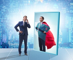Businessman seeing himself in mirror as superhero