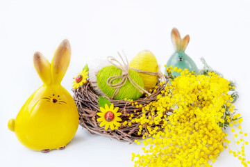 Easter eggs in a nest with a bouquet of mimosa. Arrangement With Easter Eggs And Mimosa. Spring floral concept
