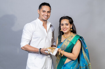 Indian couple holding gold jewelry, ornaments - Asset or Gold Loan concept.Indian couple looking...