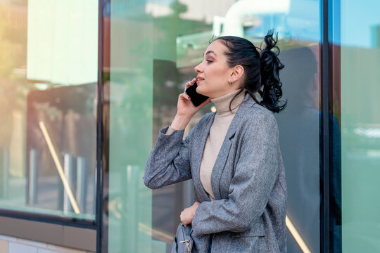 Outdoor portrait of an happy  young woman in a denim jacket is talking on the phone  Lifestyle photo
