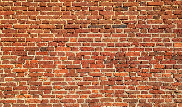 Texture of an old and damaged orange brick wall as an architectural background