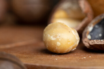 Unpeeled macadamia nuts on a wooden table
