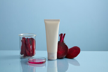 Beetroot slices are filled in a beaker, displayed with a white tube without label and a petri dish of pink liquid. Beetroot (Beta vulgaris) can help fight skin pigmentation