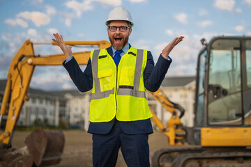 Architect at a construction site. Architect man in suit and helmet at construction site. Confident architect standing at construction. Investor or civil engineer. Outdoor portrait of hispanic