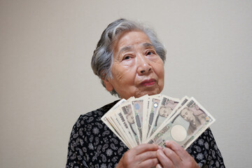 札束を持つ高齢女性