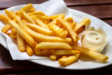 Eating of street or take away food fresh baked french fried potatoes chips with Belgian mayonnaise