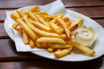 Eating of street or take away food fresh baked french fried potatoes chips with Belgian mayonnaise