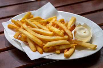 Eating of street or take away food fresh baked french fried potatoes chips with Belgian mayonnaise