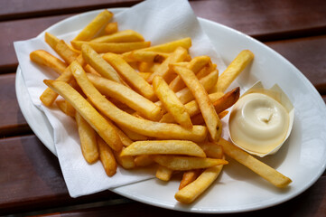 Eating of street or take away food fresh baked french fried potatoes chips with Belgian mayonnaise