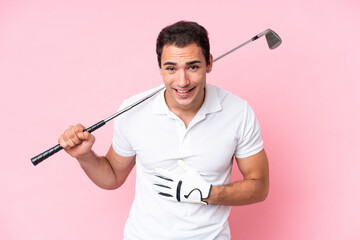 Young golfer player man isolated on pink background smiling a lot