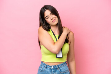 Young Brazilian woman with ID card isolated on pink background suffering from pain in shoulder for...