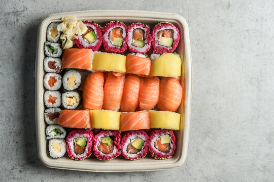 Take away sushi set in sustainable packaging on gray background, top view