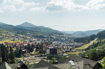 Fototapeta na wymiar A review view of the resort city in the Carpathian mountains. Roofs of houses and mountains look very atmospheric