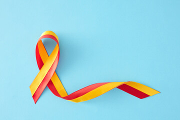 World Hepatitis Day concept. Top view flat lay of awareness ribbon on pastel blue background with empty space for message