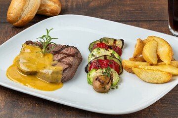 Grilled beef tenderloin with grilled vegetables on a white porcelain plate