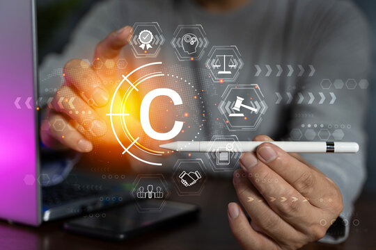 Copyright or patent concept, Person hand using laptop computer on desk with VR screen copyright icon background, Copyleft trademark license.