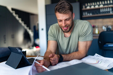 A man checks financial statements, charts for an investment fund in his company.