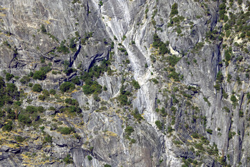 Small green trees grow on the slopes of the mountains.