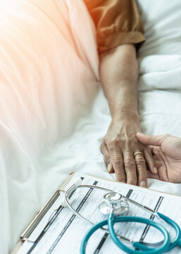 Elderly senior aged patient on bed with geriatric doctor holding hands for trust and nursing health care, medical treatment, caregiver and in-patient ward healthcare in hospital