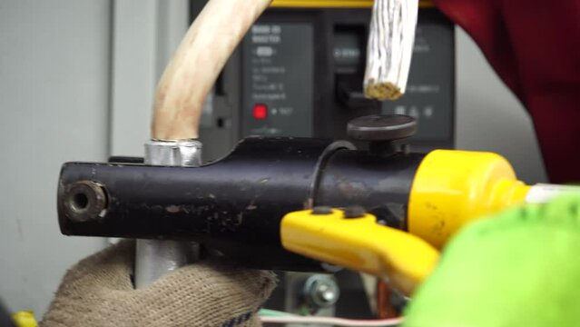 Close-up view of Electrician installing wires, cables into a electricity power shield, fuse box, an industrial electric panel with lots of colorful cables and wires. Power industry concept.