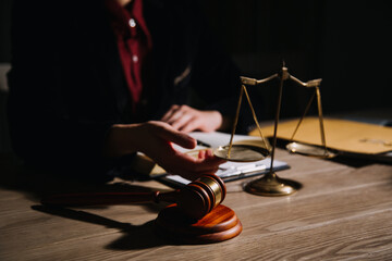 Justice and law concept.Male judge in a courtroom with the gavel, working with, computer and docking keyboard, eyeglasses, on table in morning light