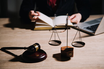 Justice and law concept.Male judge in a courtroom with the gavel, working with, computer and docking keyboard, eyeglasses, on table in morning light