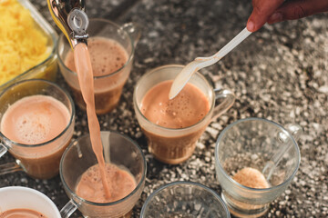Desi Black Chai in glass mugs with traditional pakistani indian sweet