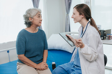 Obraz premium Beautiful modern female doctor talking to an elderly woman patient with a smiling face at the hospital.