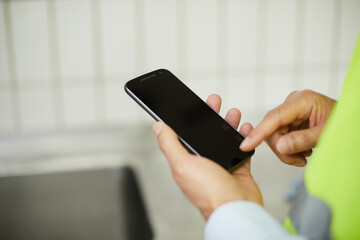 Arbeiter bedient Mobiltelefon
